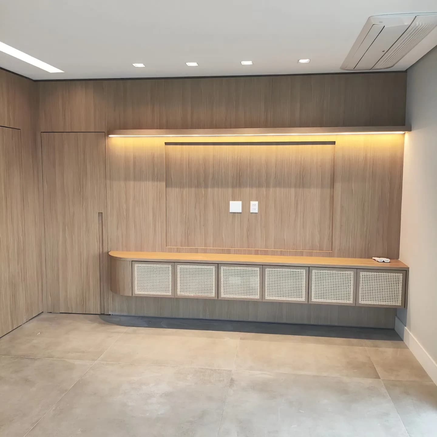 Painel living integrado com porta mimetizada: móveis planejados executados pela HACHFOX em São Paulo, SP · Jardim Pinheiros